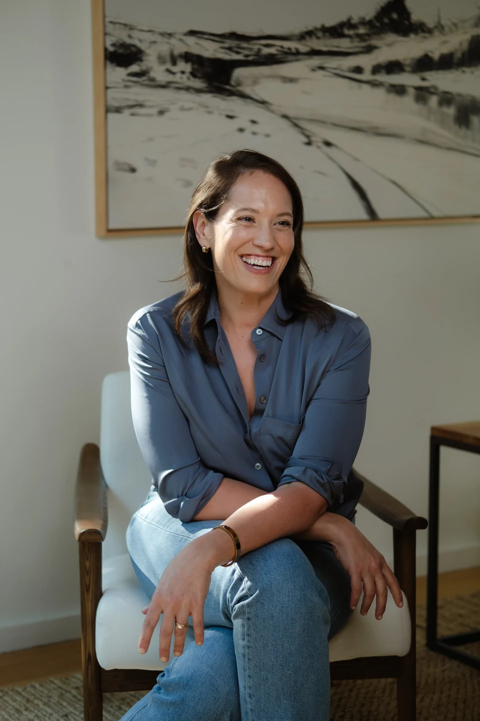 Annie Wright laughing while seated in a blue blouse.