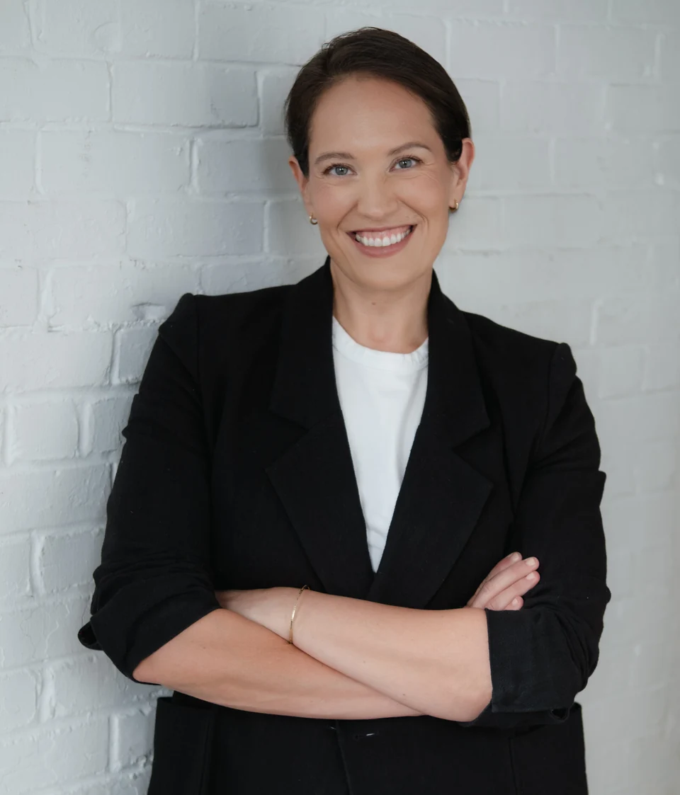 Annie Wright smiling while seated in a white blouse.