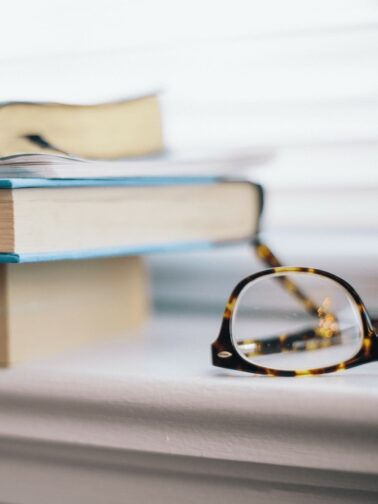 Image of glasses on top of a book. This blog is about The Top 15 Books I Recommend to Heal Your Soul, Find Your Kindred Spirits, and Discover Your Calling.