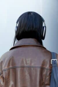 Person wearing noise-canceling headphones and a brown leather jacket, symbolizing emotional withdrawal and self-protection—concepts tied to covert narcissism and relational trauma.