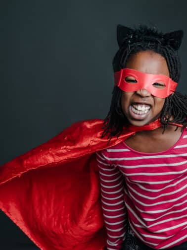 Image of girl in superhero costume representing what common childhood trauma adaptations are