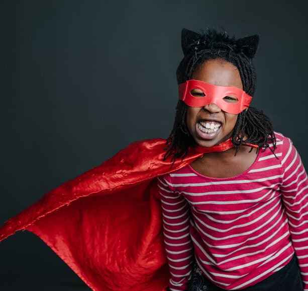 Image of girl in superhero costume representing what common childhood trauma adaptations are