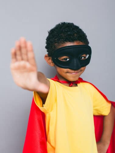 How childhood trauma adaptations are like kryptonite. Image of a young boy in mask and cape.