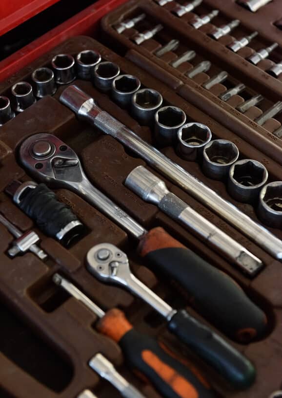 Closeup shot of shiny metal wrenches and ratchets with handles lying in special toolkit representing our resilience tools in a self-care tool chest.