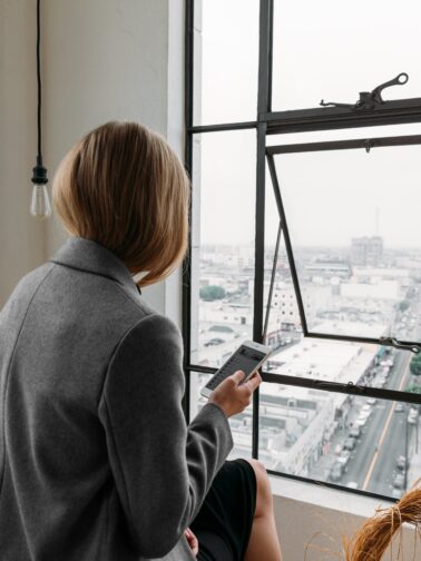 Photo of a contemplative woman in a business setting, highlighting the emotional weight of perfectionism and high-performance expectations.