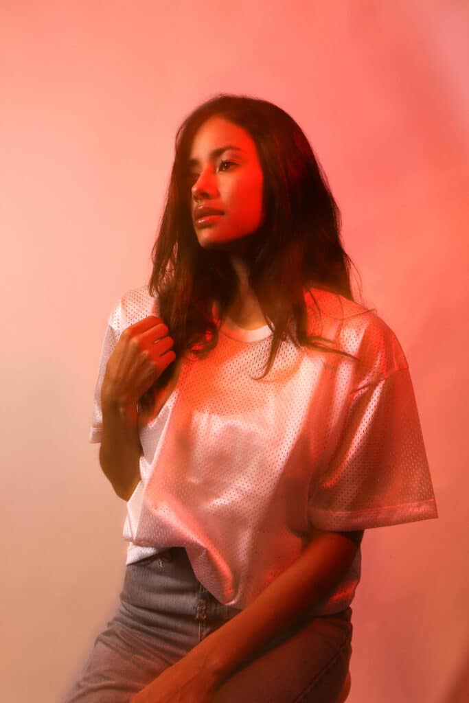 A woman bathed in soft light, gazing into the distance, symbolizing reflection and the slow emergence from trauma bonding.