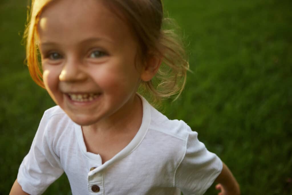 A smiling child running outside, symbolizing the innocence and joy often buried beneath the pain of trauma bonding.