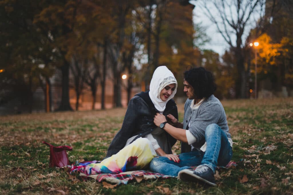 Two people sit together on a blanket outdoors, sharing a gentle moment that reflects connection and the nervous system’s capacity to feel safe after trauma.