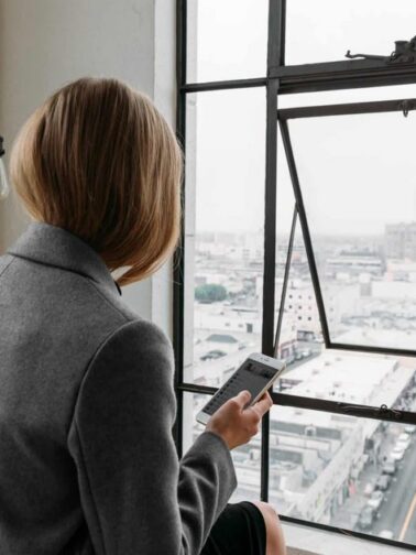 Photo of a contemplative woman in a business setting, highlighting the emotional weight of perfectionism and high-performance expectations.