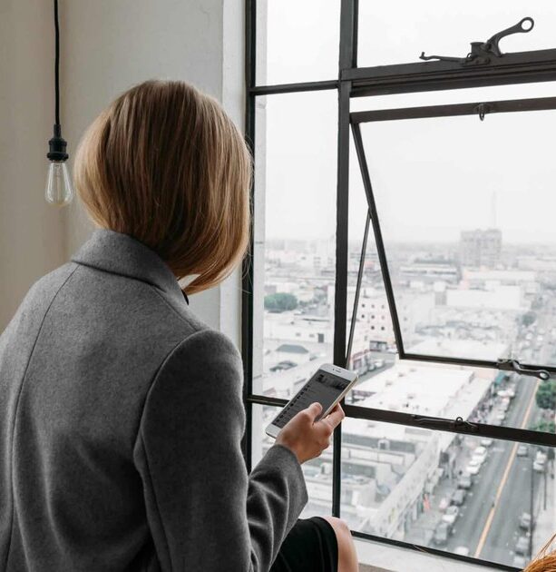 Photo of a contemplative woman in a business setting, highlighting the emotional weight of perfectionism and high-performance expectations.