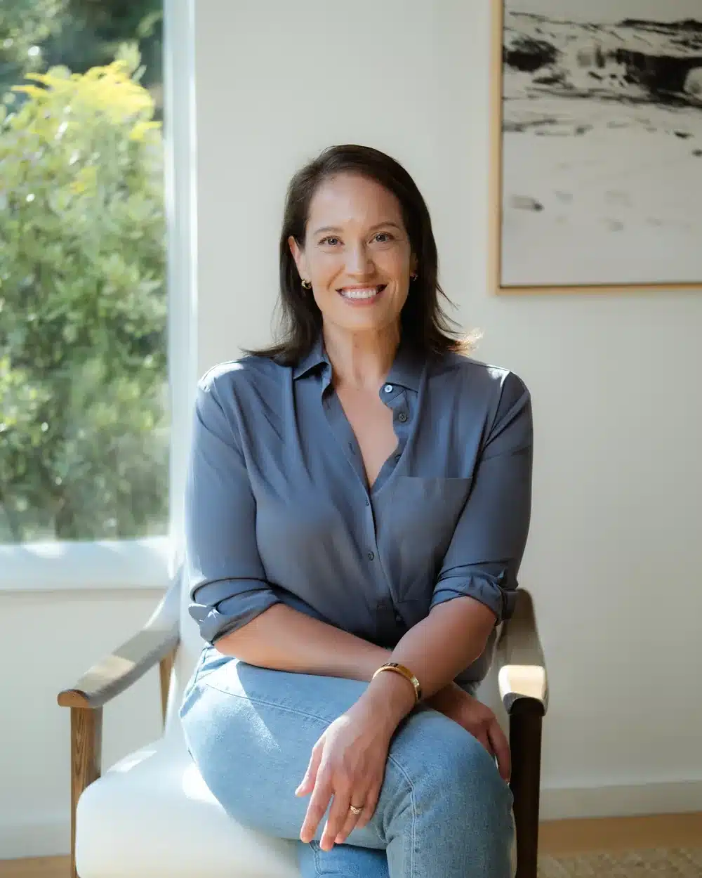 Annie Wright, LMFT, seated in a chair by a window in a calm, light-filled room